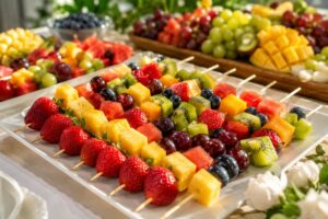 Colorful fruit skewers for parties on a serving tray with strawberries, grapes, pineapple, kiwi, and blueberries