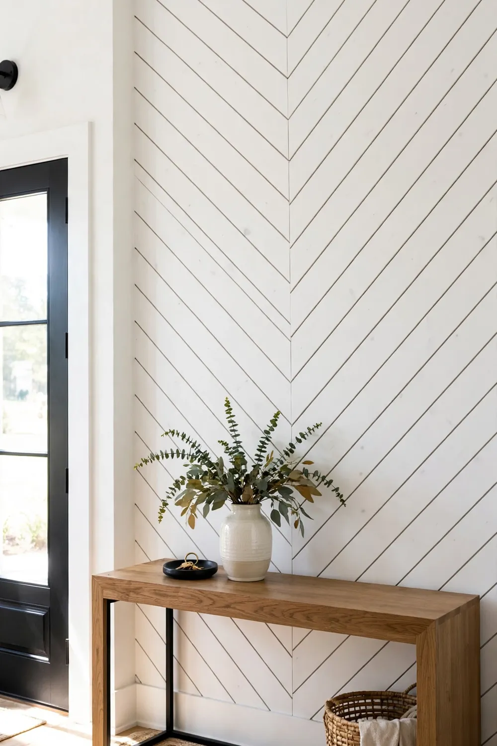 Modern entryway accent wall with white shiplap boards installed in a chevron pattern