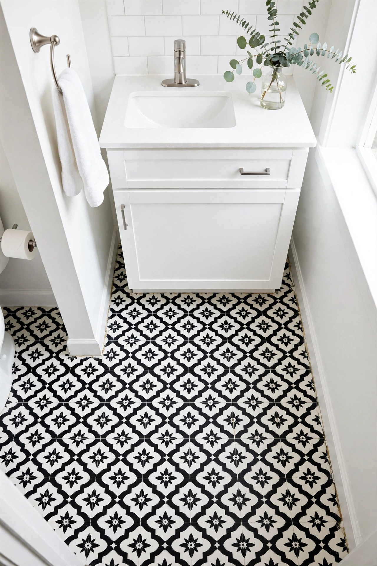 Rental bathroom floor with peel-and-stick black and white patterned vinyl tiles